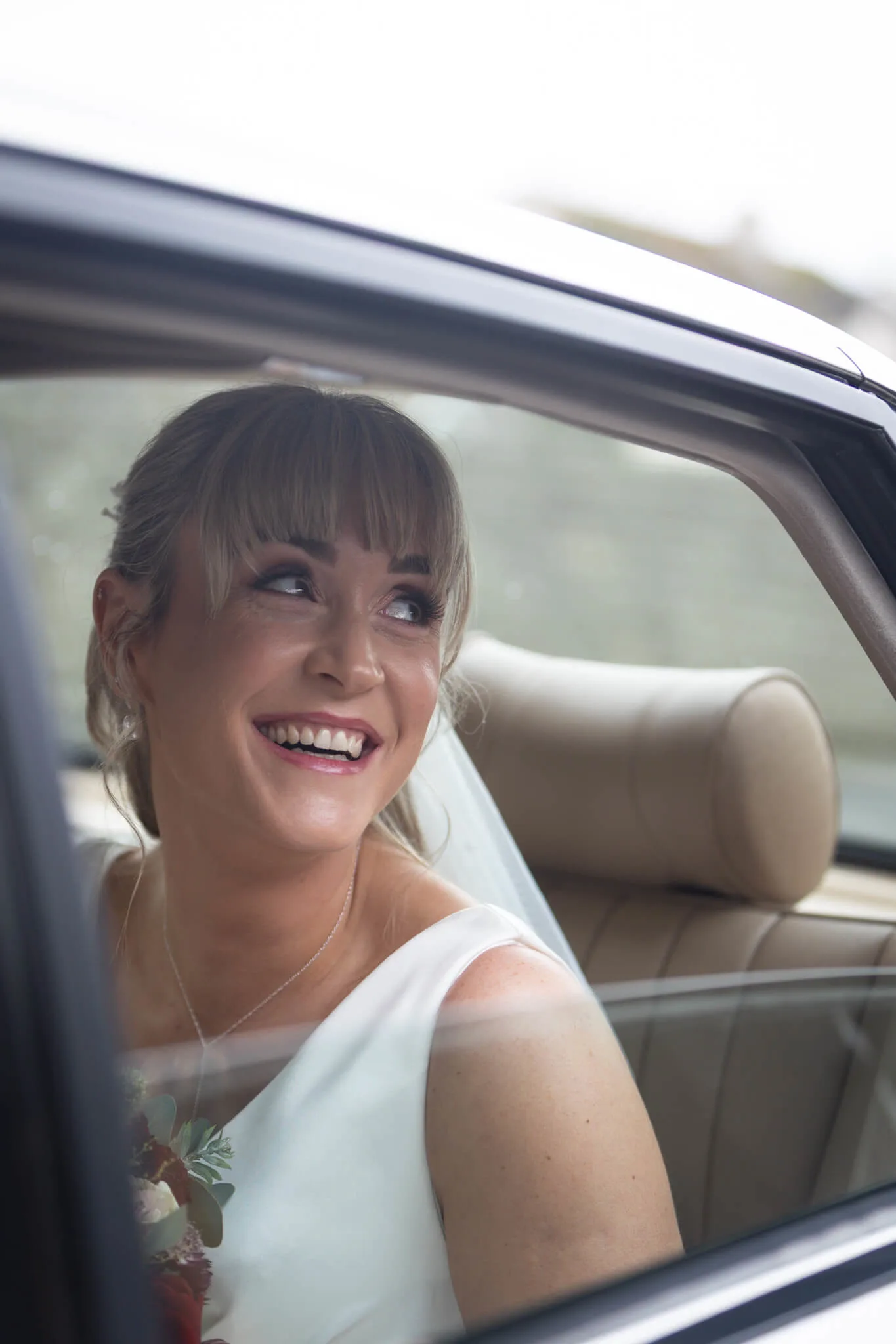 Bride smiling in a car